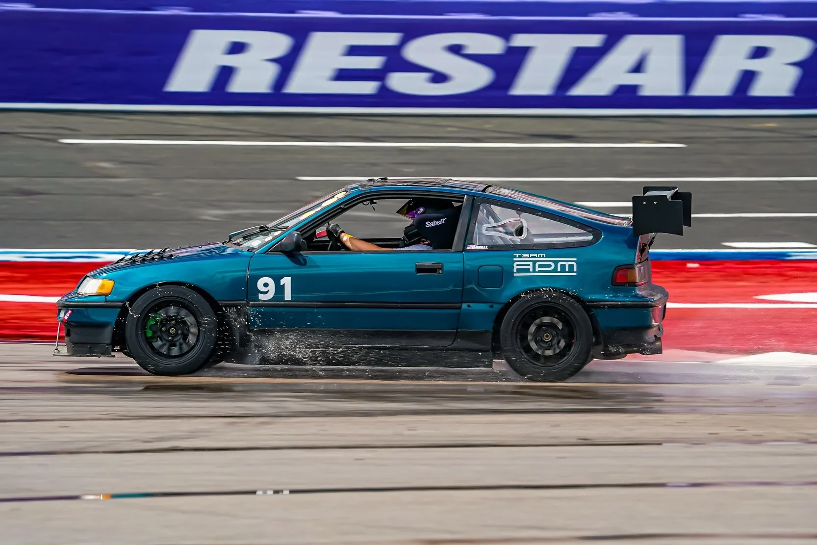 Teal Honda CRX number 91 launching at the drag strip