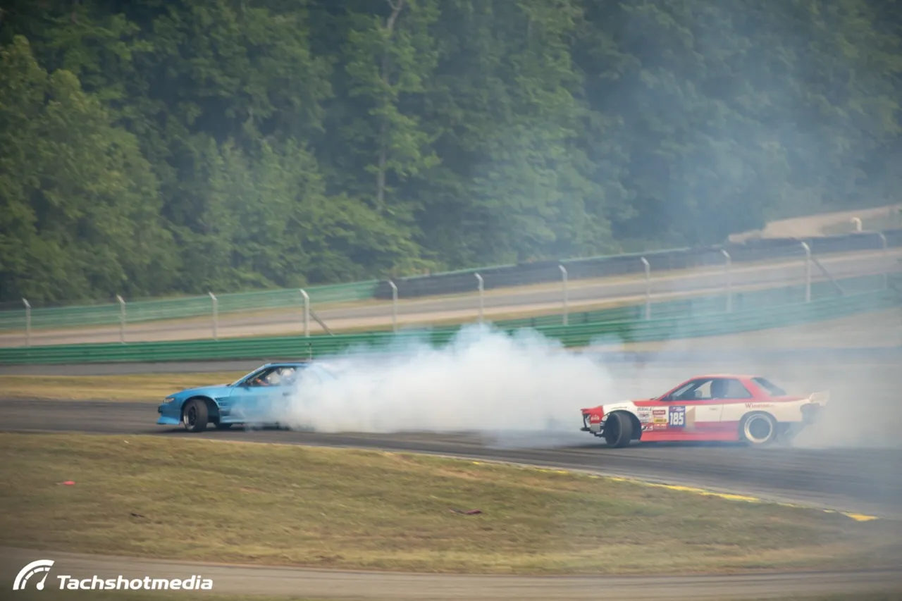 Blue S13 and number 185 S-chassis tandem drifting in smoke at VIR